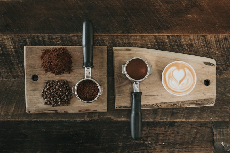 Portafilters, fresh grounds and latte art on a wooden board